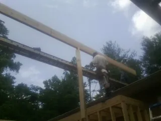 Carpenter setting a ridge beam over a new addition frame — Ice Dam Removal by Roofing Brothers in Park Forest