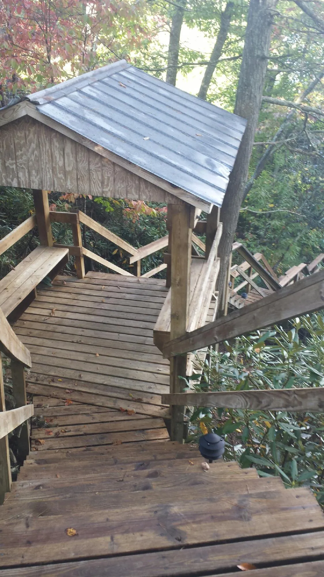 Metal roofed shelter over wooden steps on a wooded walkway — Skylight Repair & Installation work by our crew in Park Forest