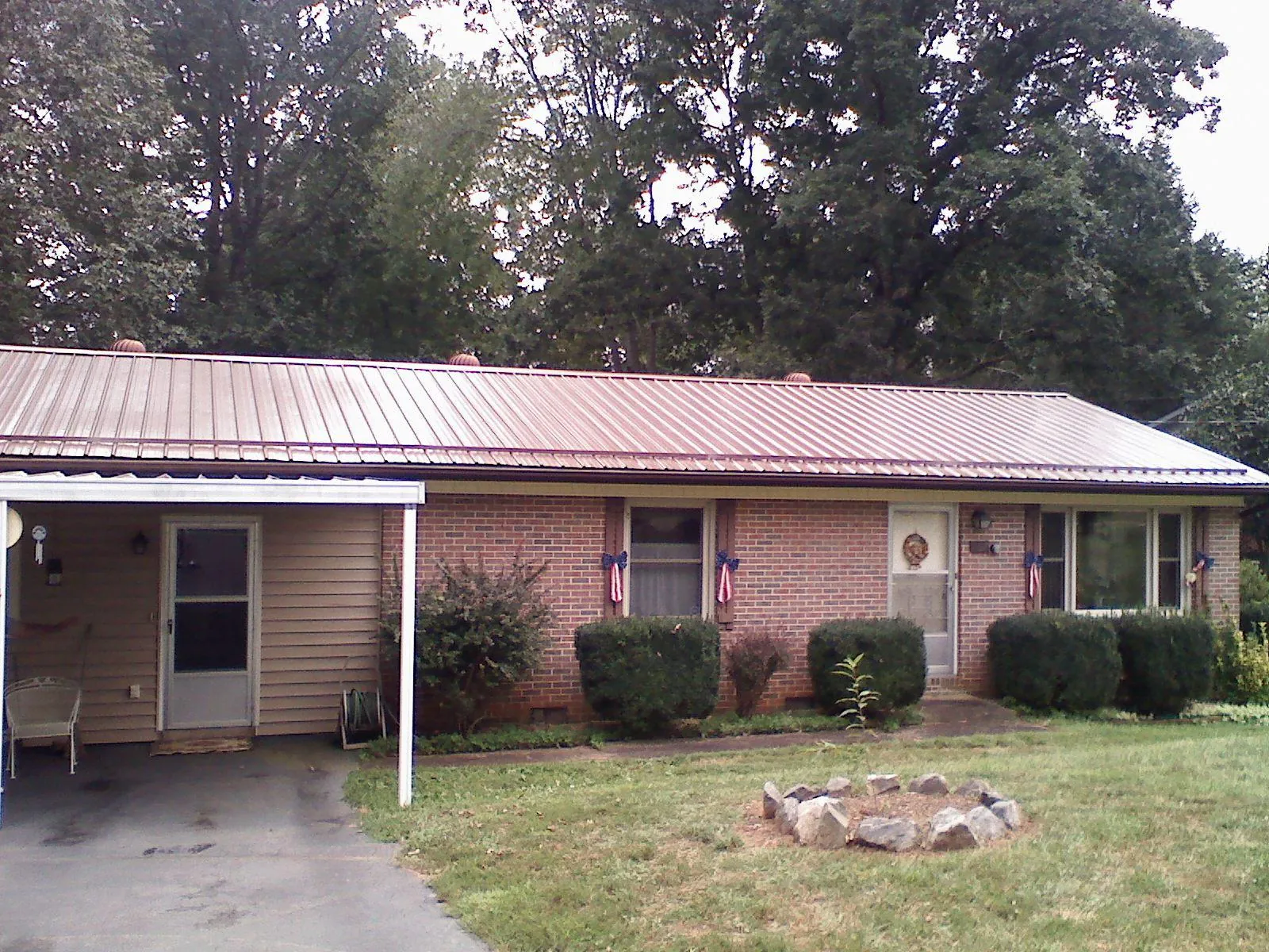 Bronze metal roof and carport on a brick ranch home — Roof Repair work by our crew in Park Forest
